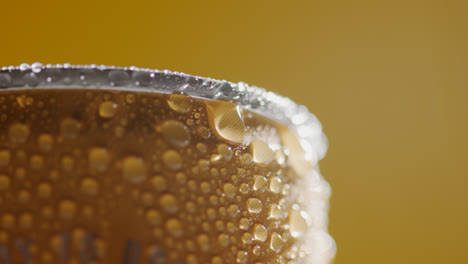 Primer-Plano-De-Gotas-De-Condensación-En-Una-Lata-Giratoria-De-Cerveza-Fría-O-Refresco-Para-Llevar-Sobre-Fondo-Amarillo-Con-Espacio-Para-Copiar-2